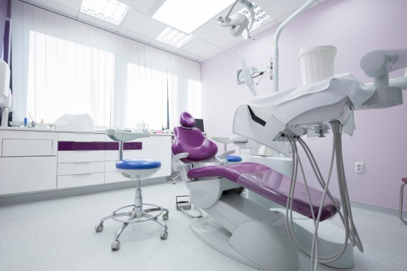 Behandlungszimmer mit lila Zahnarztstuhl